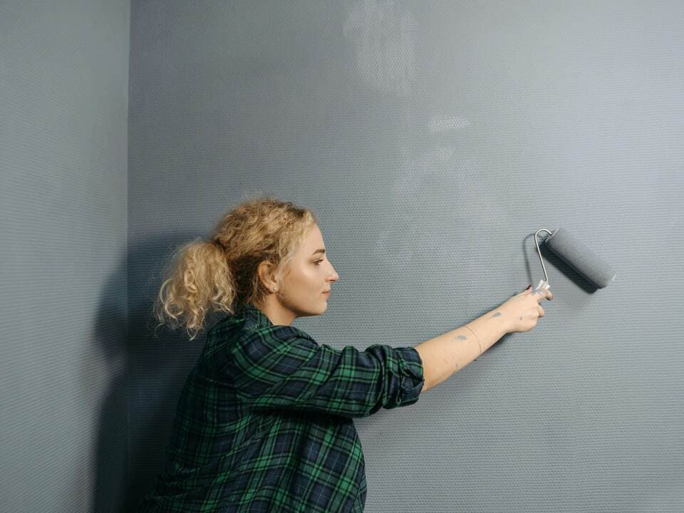 Painter and decorator painting wall